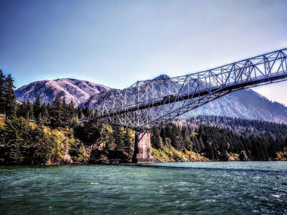 The Bridge of the Gods spans the Columbia River at Cascade Locks. The mountains of Oregon rise in the background.